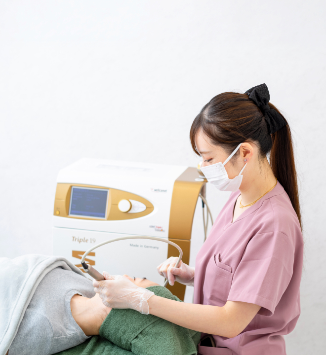 スリジエクリニックの看護師が美容医療機器で施術を行う様子